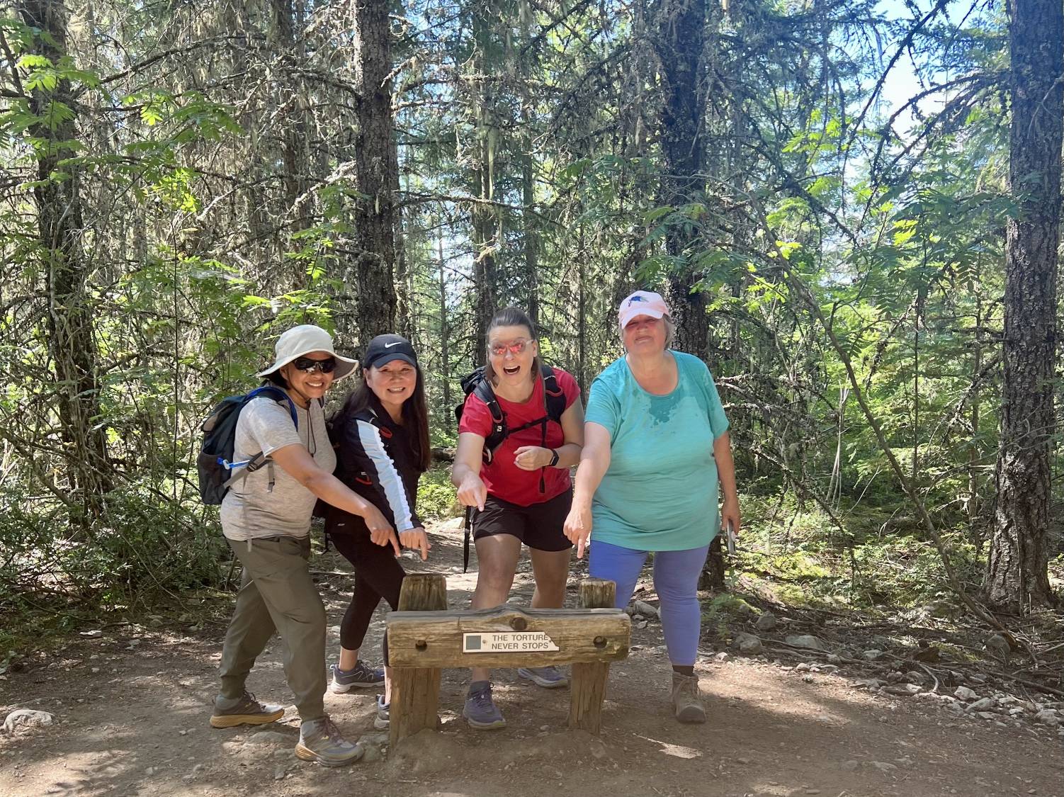 Women pointing at a fun sign in the forest